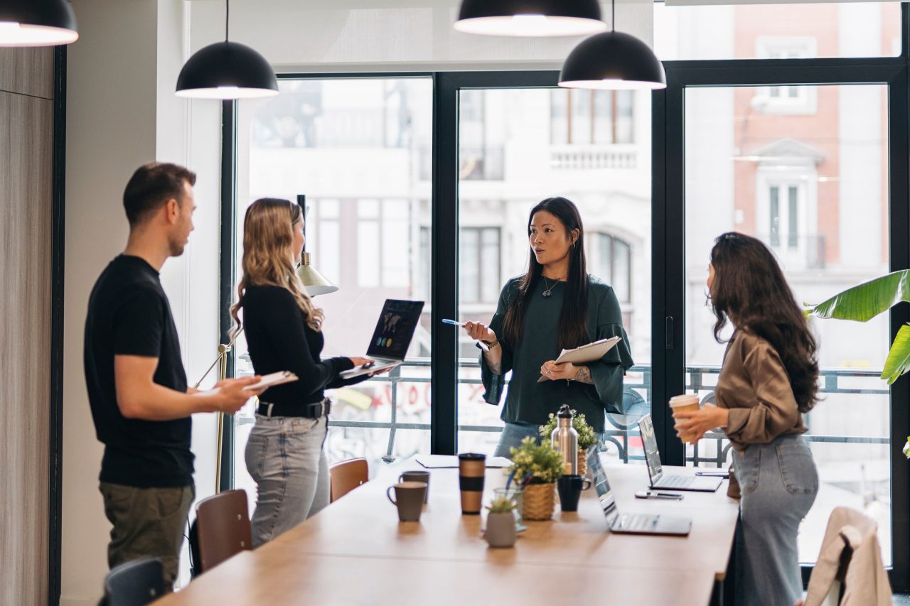 A diverse group of professionals engaged in a team discussion in a bright, modern office. Teamwork concept